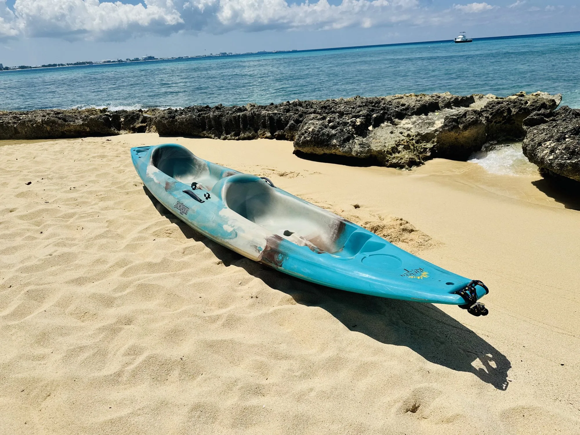 Blue kayak pulled up on a sandy beach