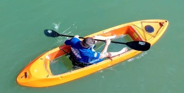 Paddler in a sea-through single kayak