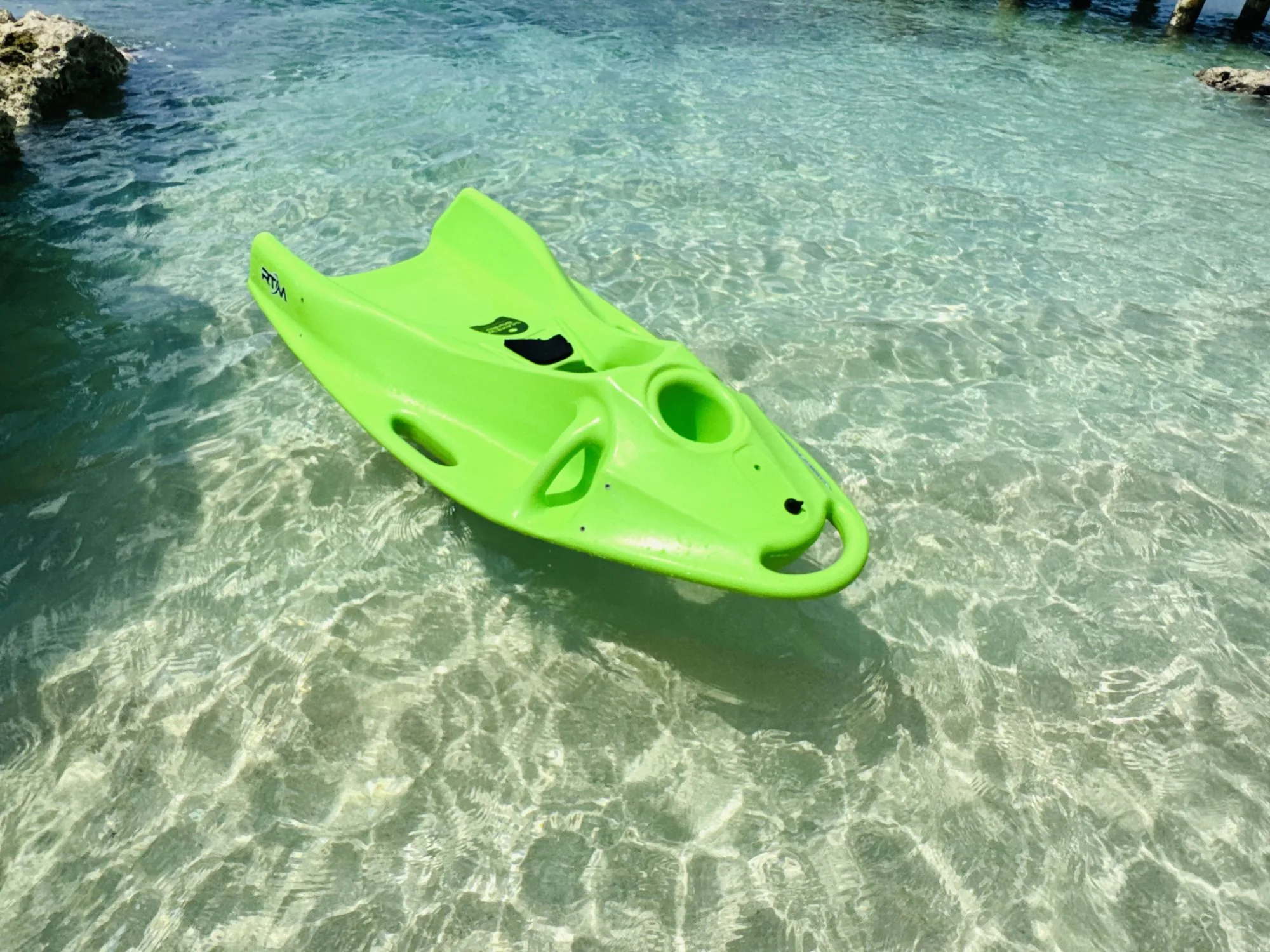 Reef Board (green) floating in clear shallow water