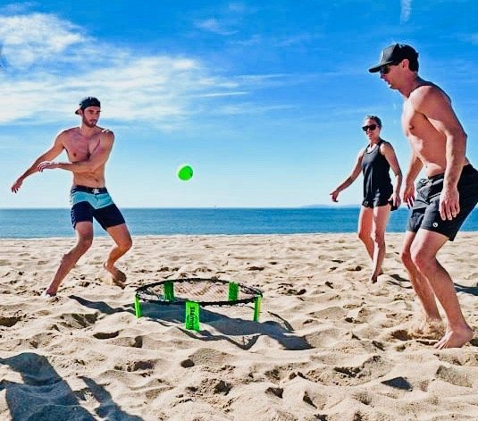 Friends playing Slam Ball on the beach