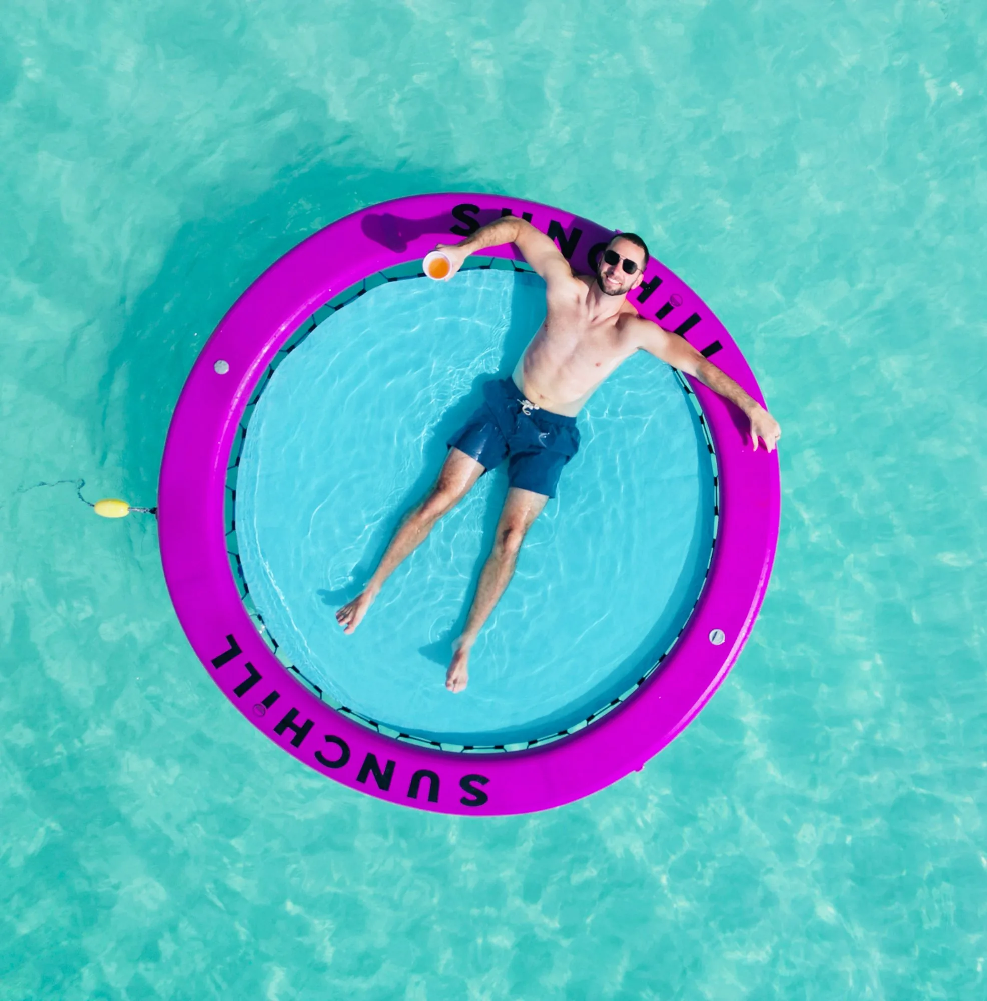 Man relaxing in a round water hammock